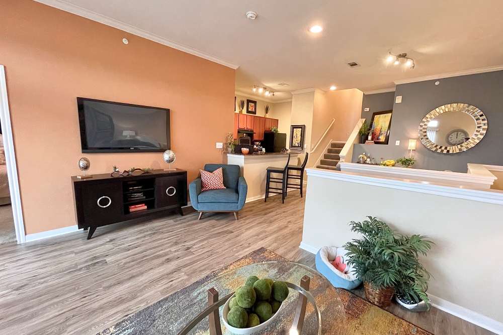 Thoughtfully designed living room with large space for lounge chairs and flat television at The Abbey at Stone Oak in San Antonio, Texas