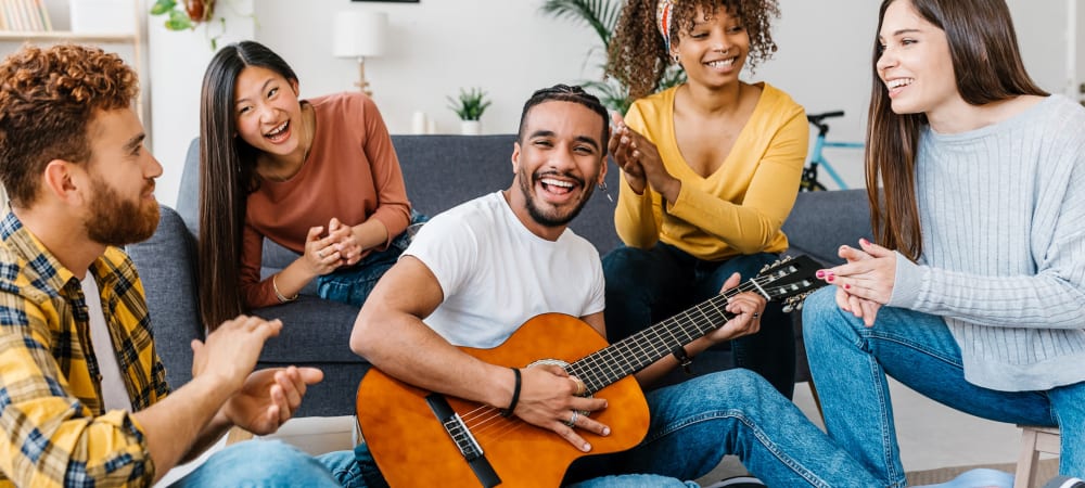 Friends gather around guitarist at University Lofts at Greensborough Village, Jonesboro, Arkansas