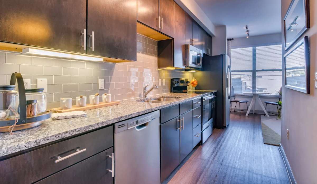 Cozy kitchen with wood-style flooring and cabinetry at The Carillon in Nashville, Tennessee