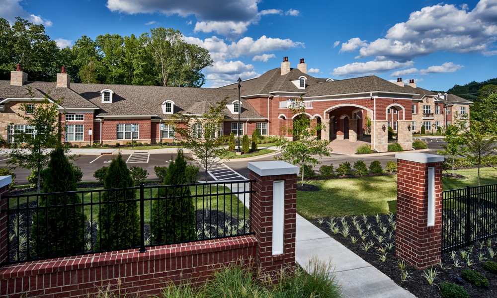 Brick community building with landscaped entrance at Waltonwood Cotswold in Charlotte, North Carolina  