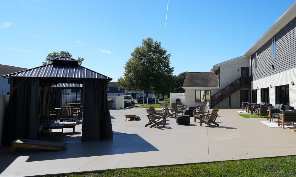 Outdoor sitting area of a clubhouse with chairs, couches and shaded pergola at River Club in Evansville, Indiana