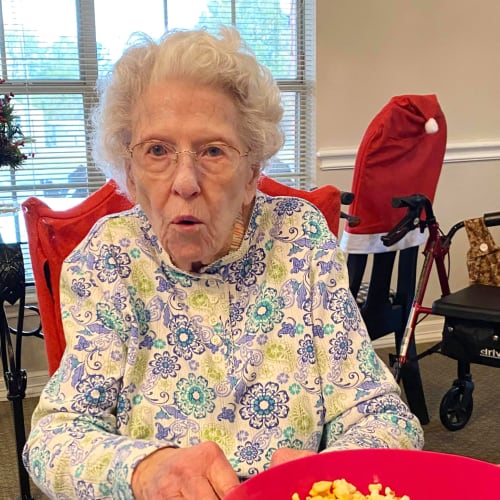 A resident sitting with a bowl of popcorn at Canoe Brook Assisted Living in Ardmore, Oklahoma