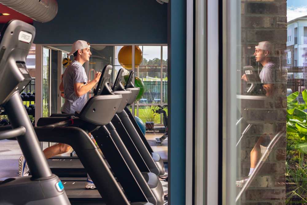 Resident working out in the community fitness center at The Flats at Ransley in Pensacola, Florida