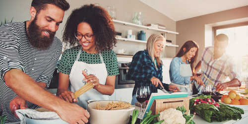 A group of friends cooking in their kitchen at Country Views Apartments in Fallbrook, California