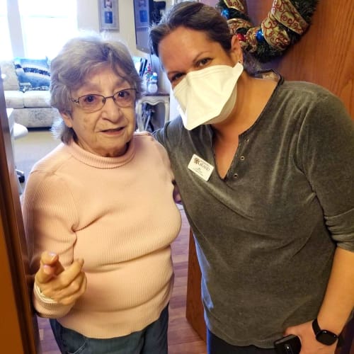 A masked team member with a resident at The Oxford Grand Assisted Living & Memory Care in Wichita, Kansas