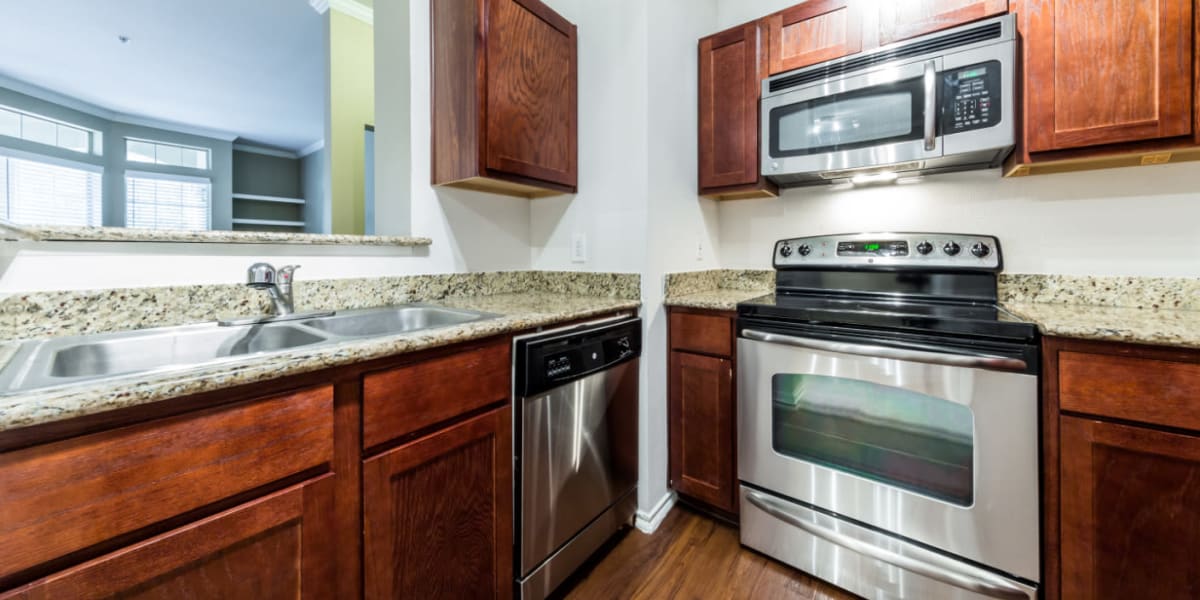 Modern kitchen with stainless steel appliances and granite counters at Marquis at Barton Trails in Austin, Texas