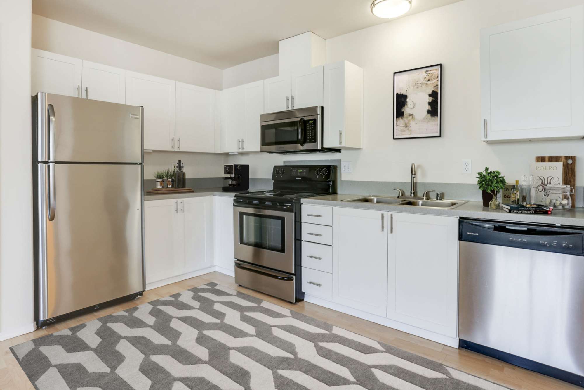 White kitchen with stainless steel appliances at The Addison Apartments in Vancouver, Washington