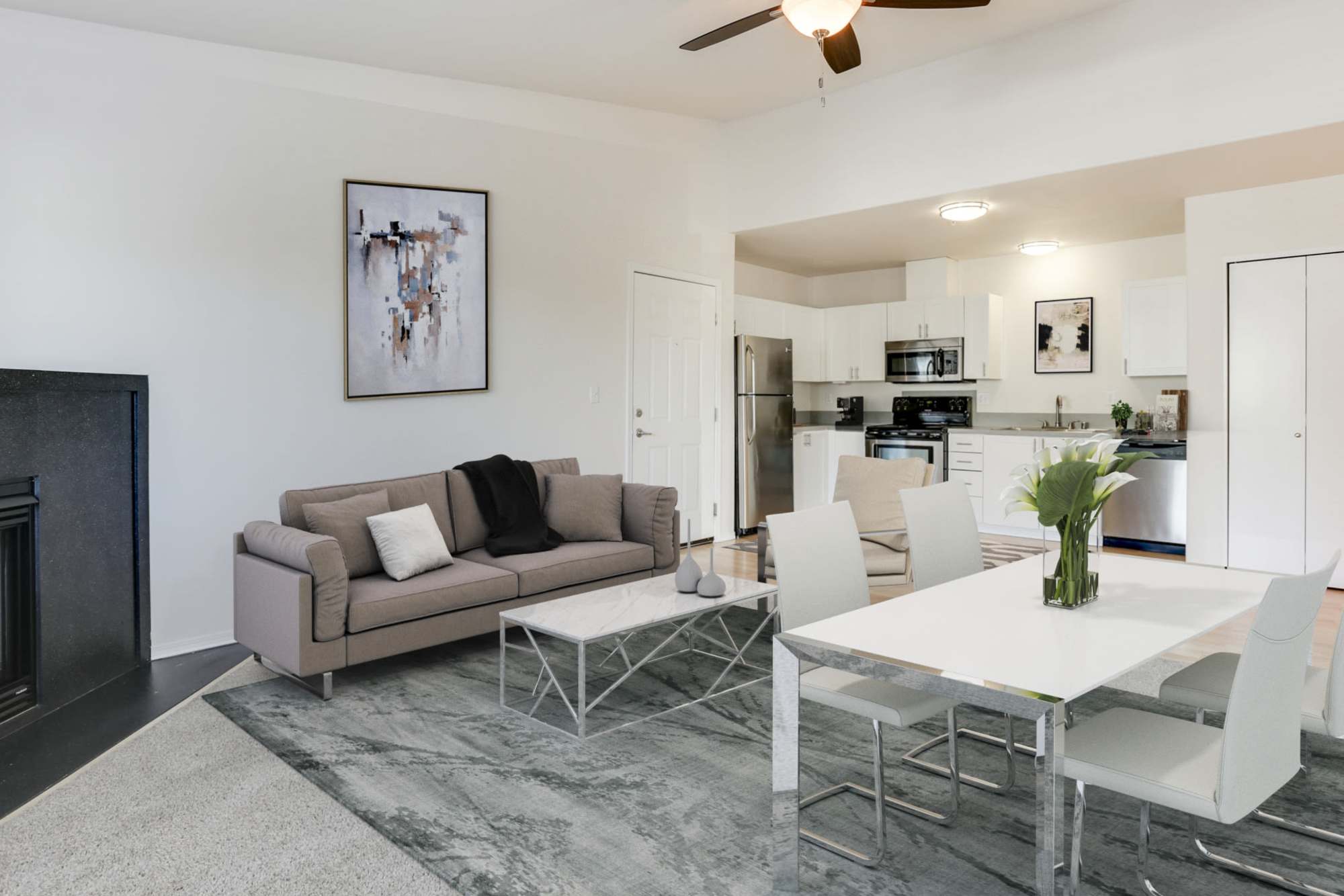 Renovated kitchen with white cabinets and a hallway view at The Addison Apartments in Vancouver, Washington
