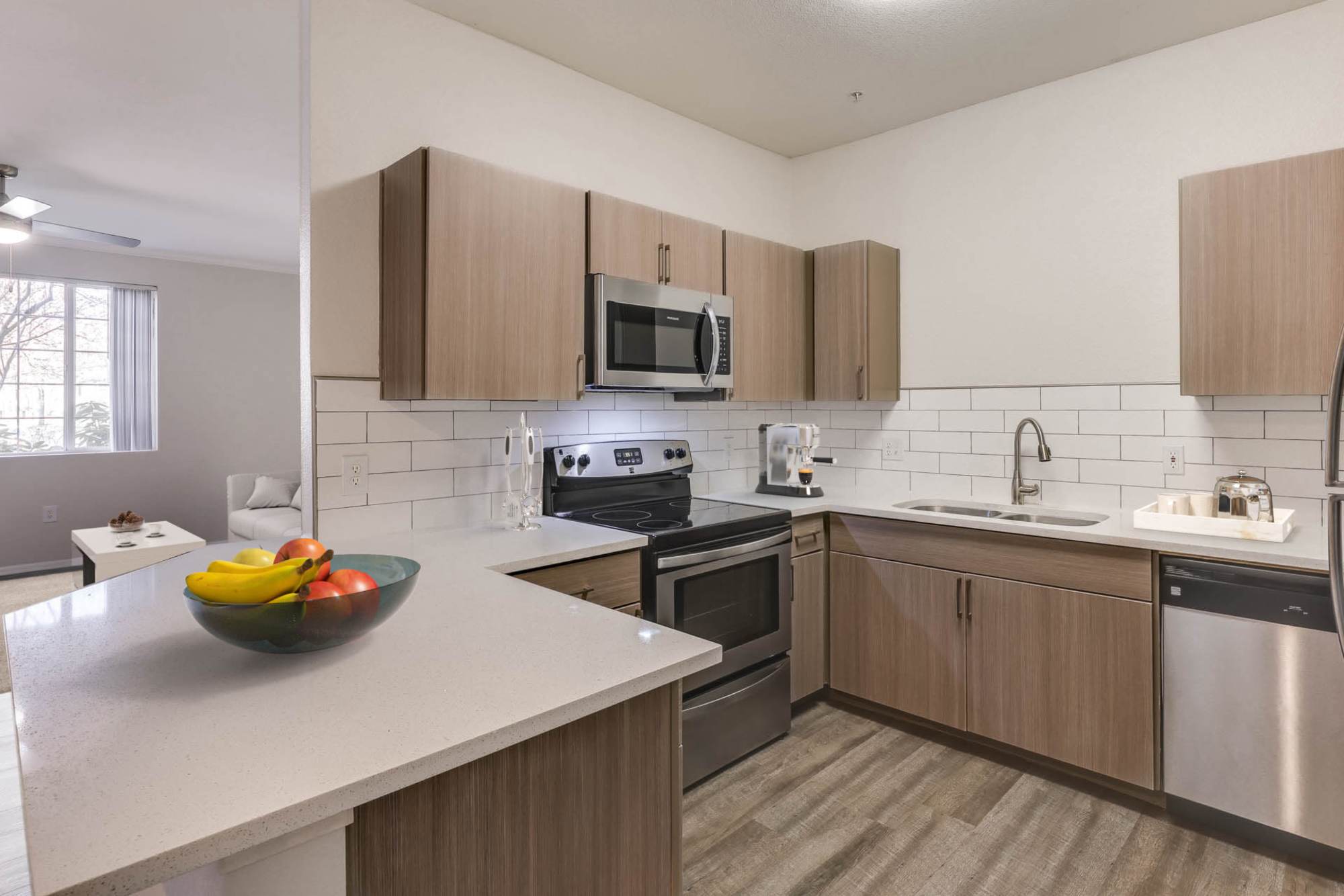 A large kitchen with white features and stainless steel appliances at The Grove at Orenco Station in Hillsboro, Oregon