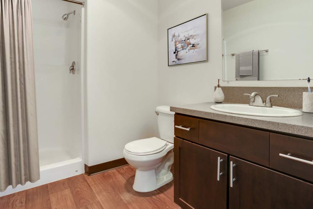 Renovated bathroom with brown cabinets at The Addison Apartments in Vancouver, Washington
