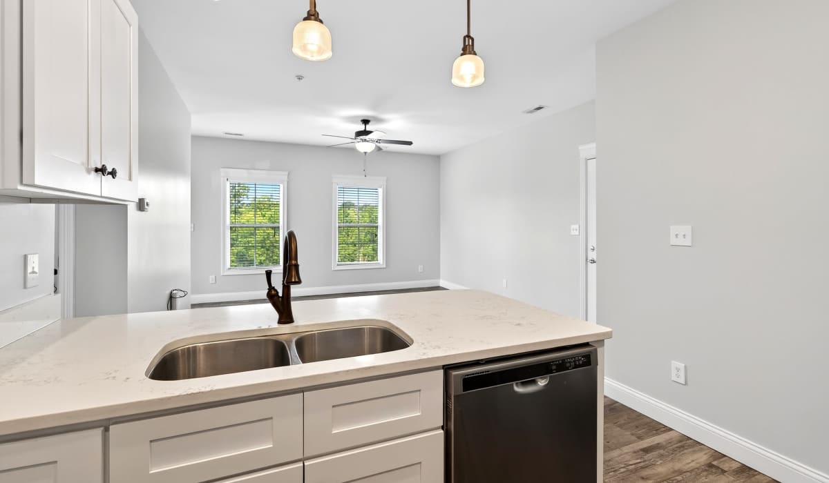 Kitchen with diswasher and view to unfurnished living room at Palomar Woods in Lexington, Kentucky