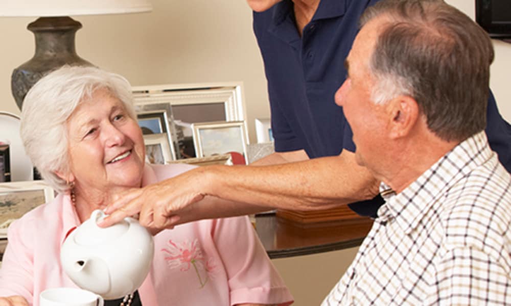 A resident talking to a caretaker at one of Americare Senior Living's locations