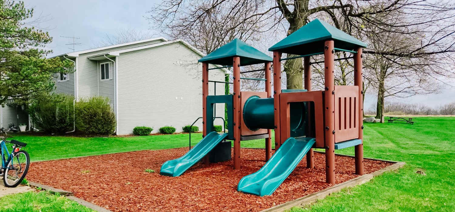 Kids play area with a slide at Mayville Apartments in Mayville, Michigan
