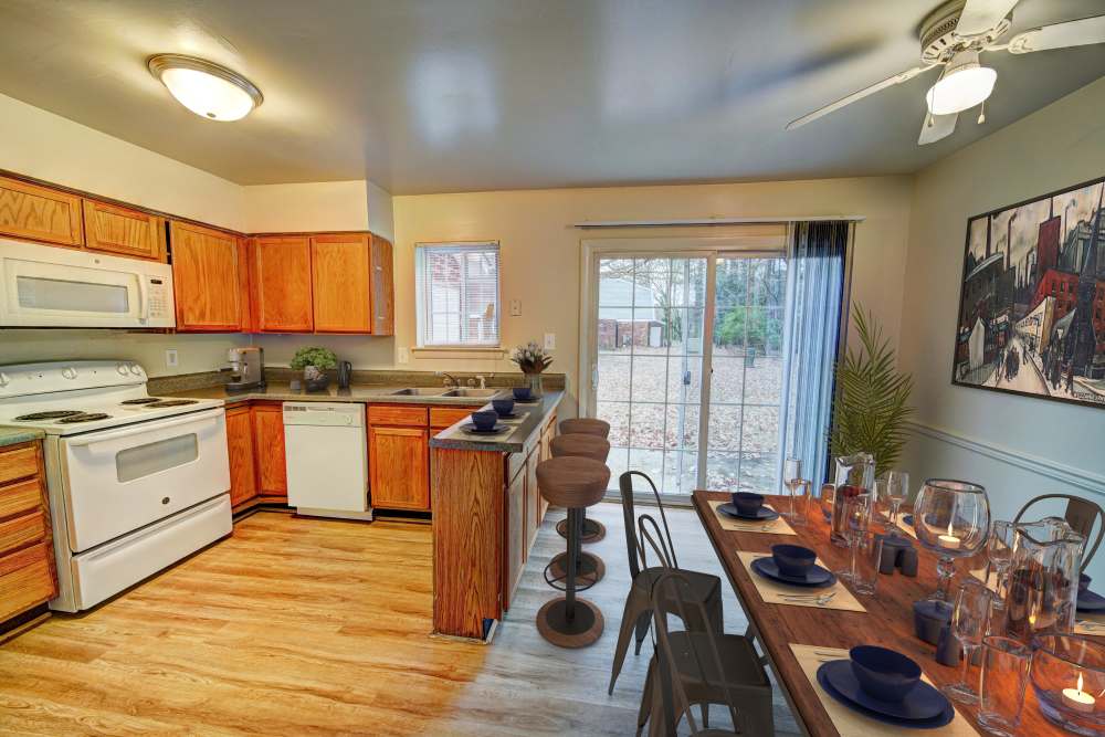 Modern apartment kitchen with white appliances at Hickory Point Townhomes in Newport News, Virginia