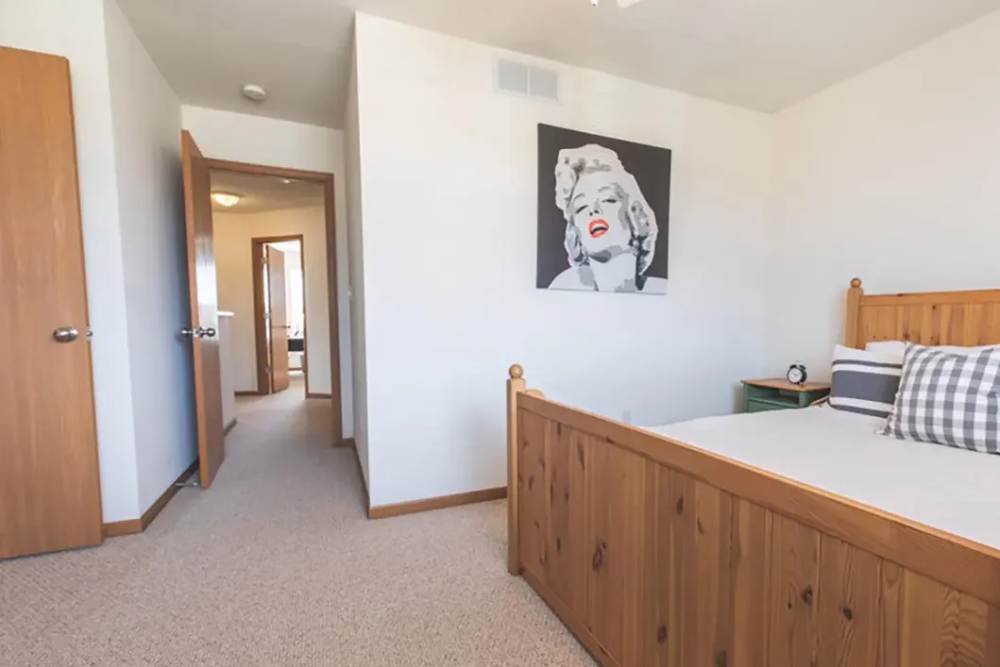 Modern bedroom with wooden style flooring at Cross Creek Villas in Columbia, Missouri