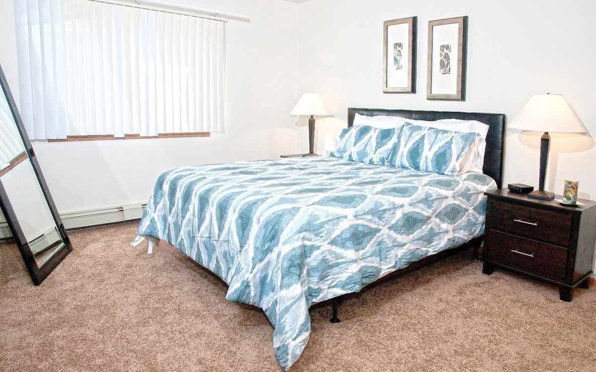 Model bedroom with a large bed at Redland Arms Apartments in Florida City, Florida