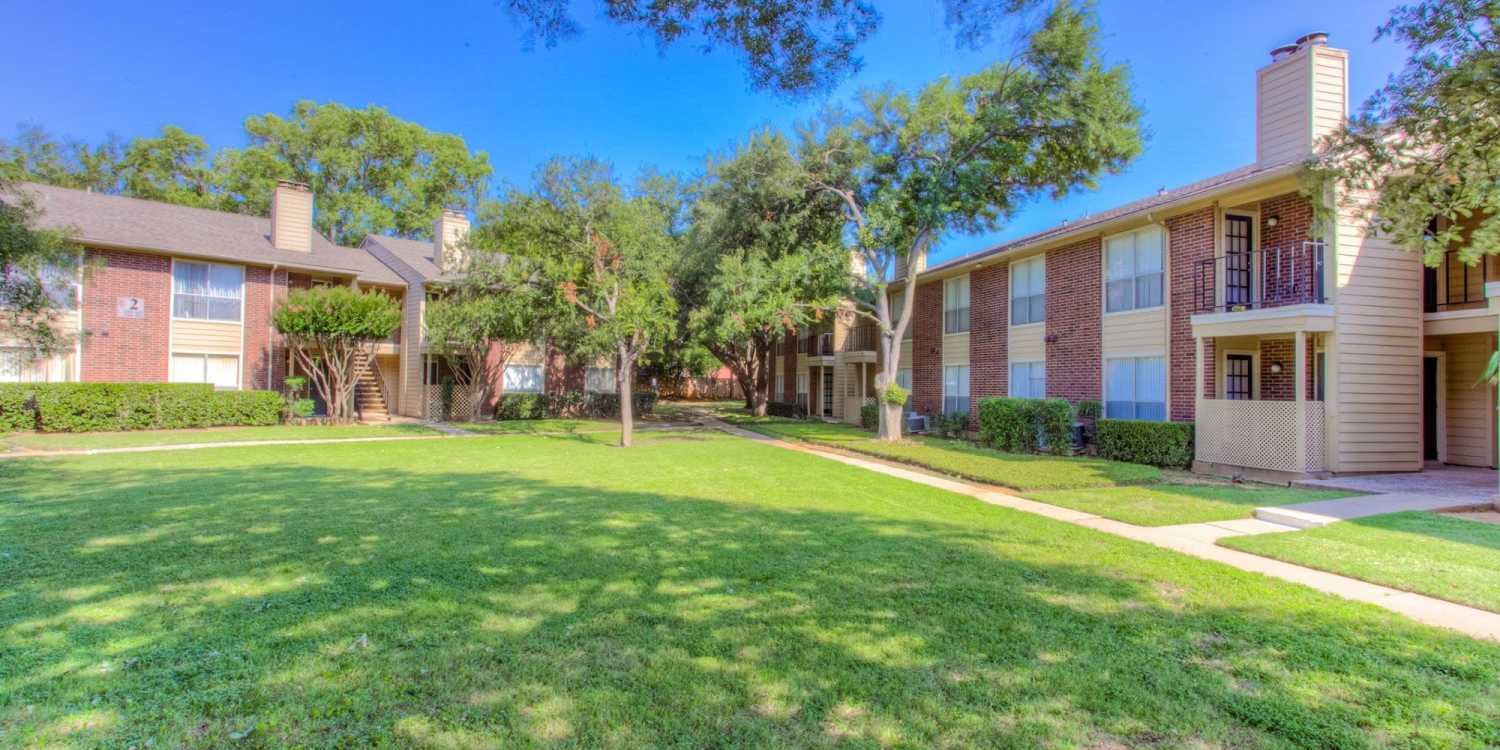 Charming outdoor space with lush landscaping and inviting pathways at Charter Oak in Euless, Texas.