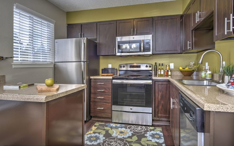 Enjoy updated espresso cabinetry in kitchens at Arapahoe Club Apartments in Denver, Colorado