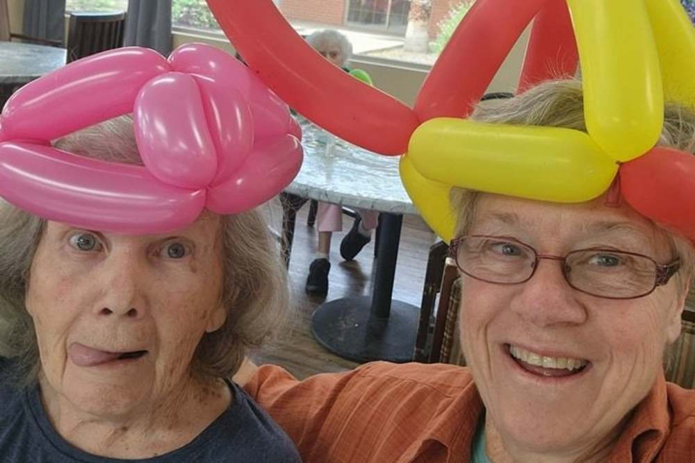 Ladies wearing balloon hats at Woodland Palms Memory Care in Tucson, Arizona