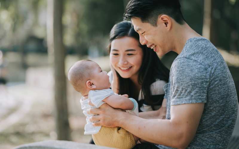 Happy couple holding their baby near Hart Townes in Woodruff, South Carolina