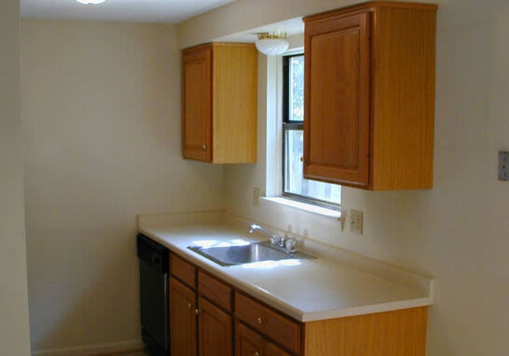 Kitchen with wooden cabinets and window light at Jefferson Manor Townhomes in Fairport, New York