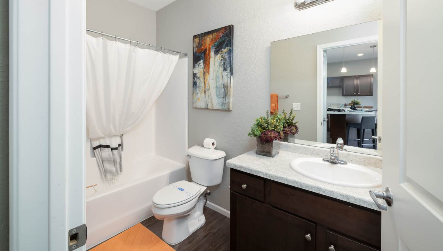 Bathroom with large mirror and vanity lights at University Commons in Williston, North Dakota