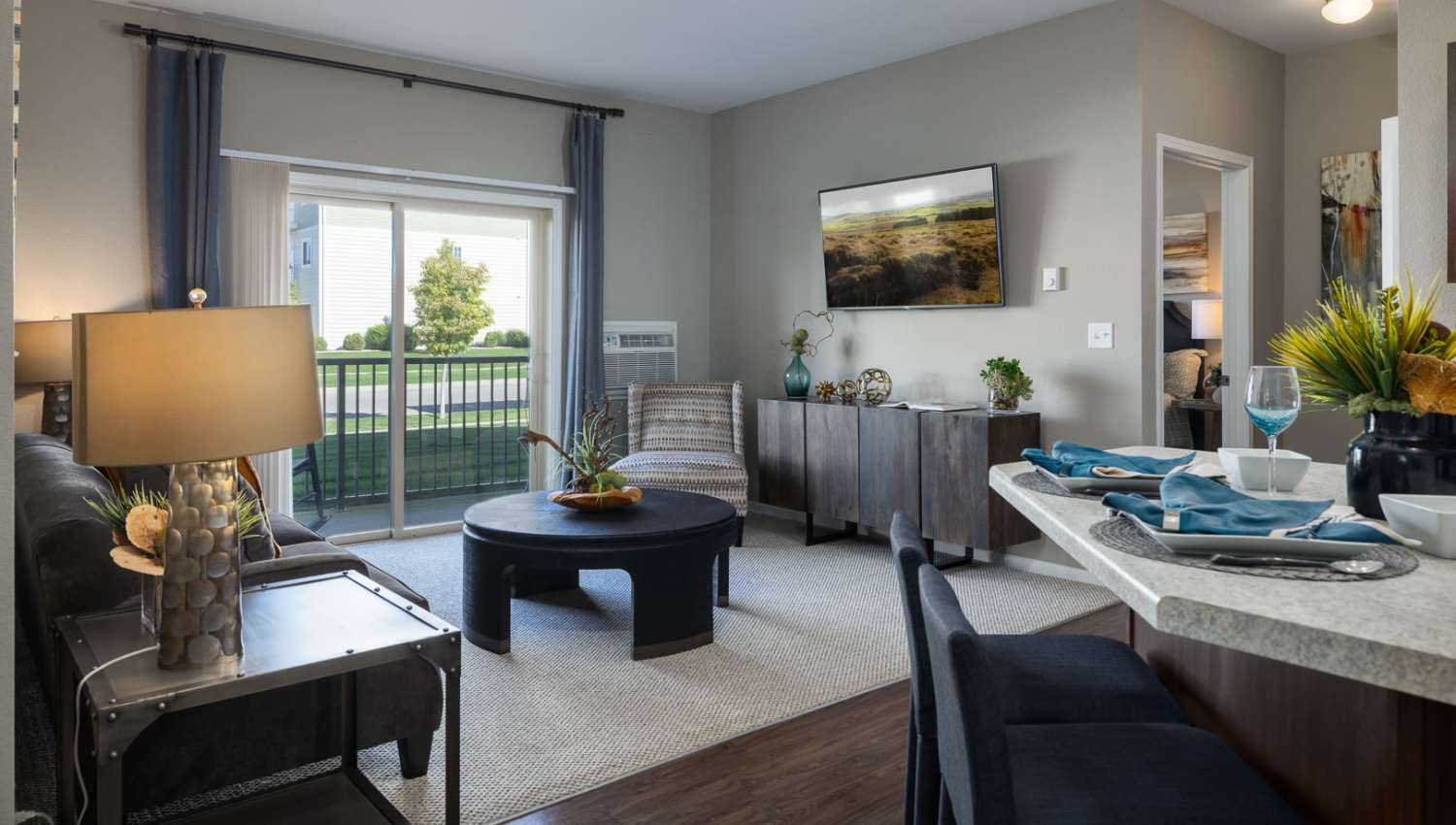 Spacious Living area with couch and way to patio access at University Commons in Williston, North Dakota