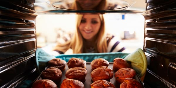 Caretaker pulling muffins out of the oven at Maple Ridge Care Center in Spooner, Wisconsin