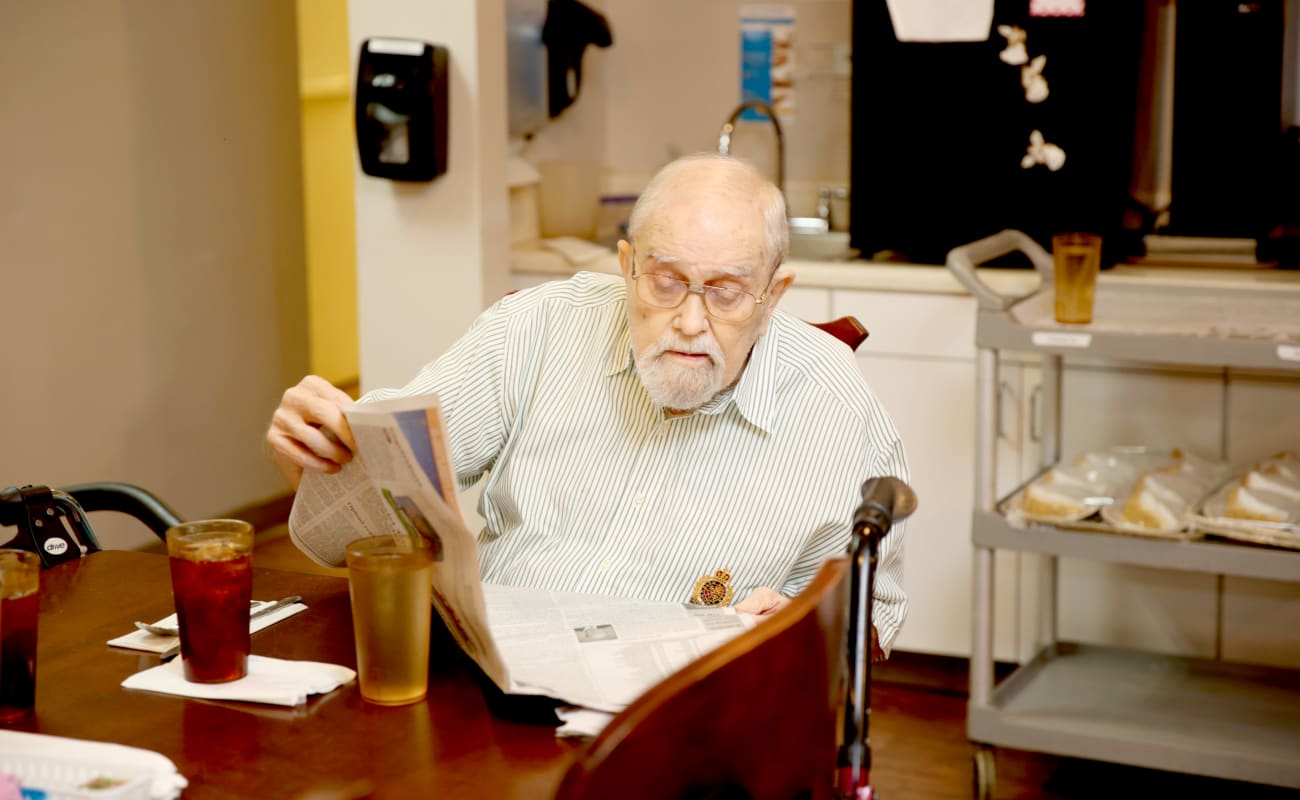 A resident reading the paper at breakfast at Providence Assisted Living in Grenada, Mississippi.