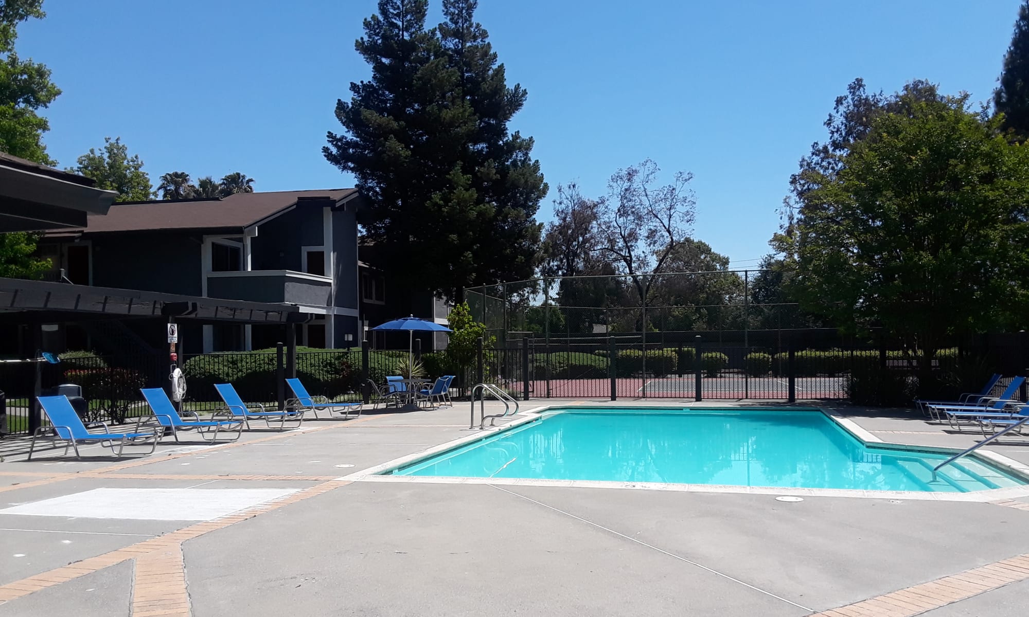 Exterior Pool shot with lounges, tennis court in background in Fairfield, CA