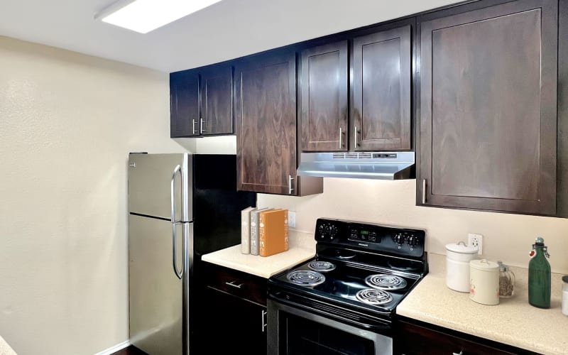 A renovated kitchen with espresso cabinets at Hillside Terrace Apartments in Lemon Grove, California