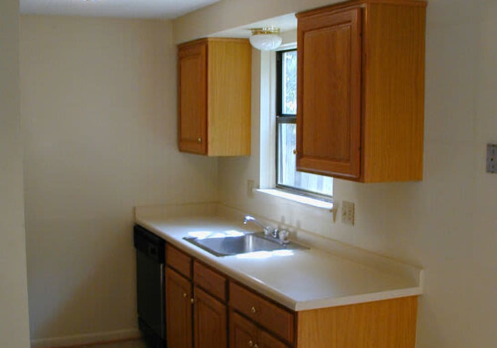 Cozy kitchen with wood-style cabinetry at Jefferson Manor Townhomes in Fairport, New York
