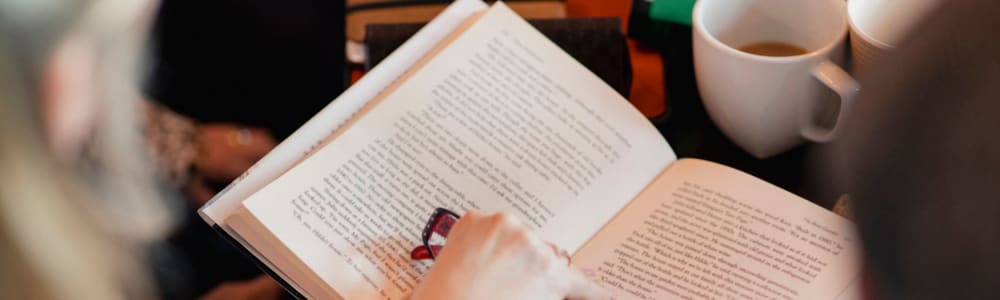 A resident reading a book while enjoying a cup of tea