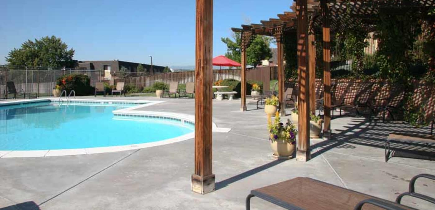 Swimming pool and shaded seating under pergola at Montair Apartment Homes in Thornton, CO