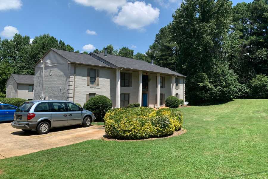 Lush lawn and treeline surrounding Britain Village in Lawrenceville, Georgia