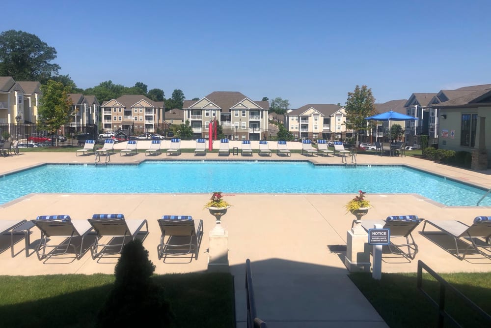 Clubhouse and resident buildings behind the swimming pool on a beautiful day at The Retreat at Arden Village Apartments in Columbia, Tennessee