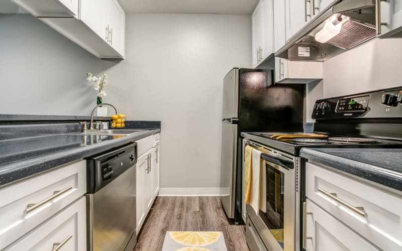 Renovated kitchen with white cabinets at The Timbers Apartments in Hayward, California