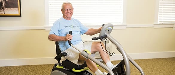 Resident on exercise bike at The Enclave at Cedar Park Senior Living in Cedar Park, Texas