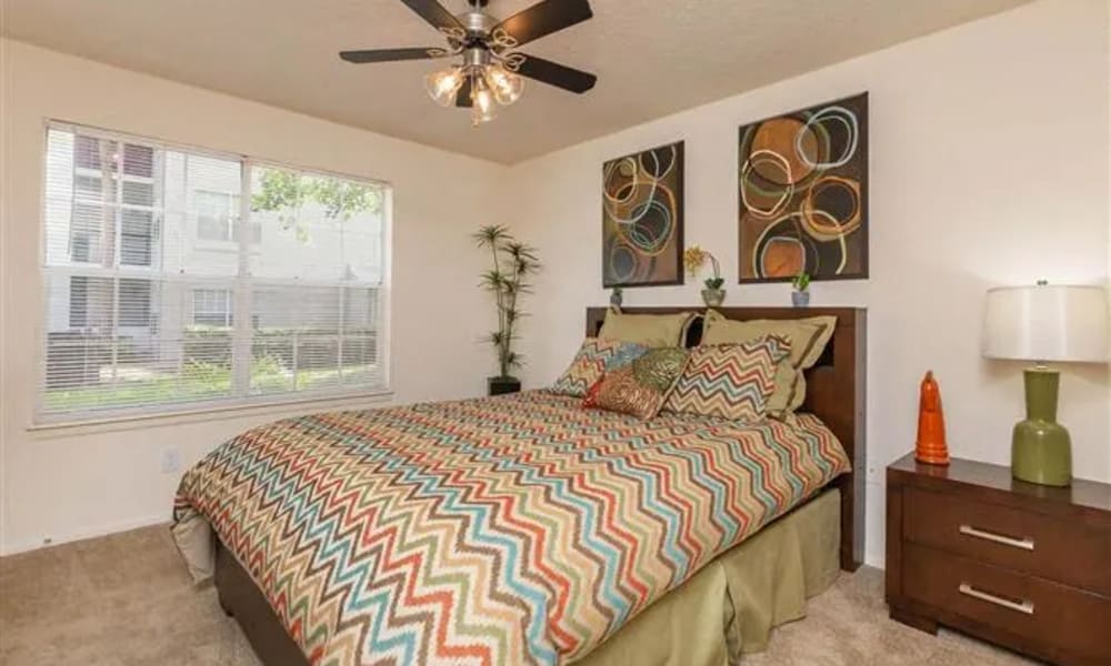 A furnished bedroom with a ceiling fan at The Granite at Porpoise Bay in Daytona Beach, Florida