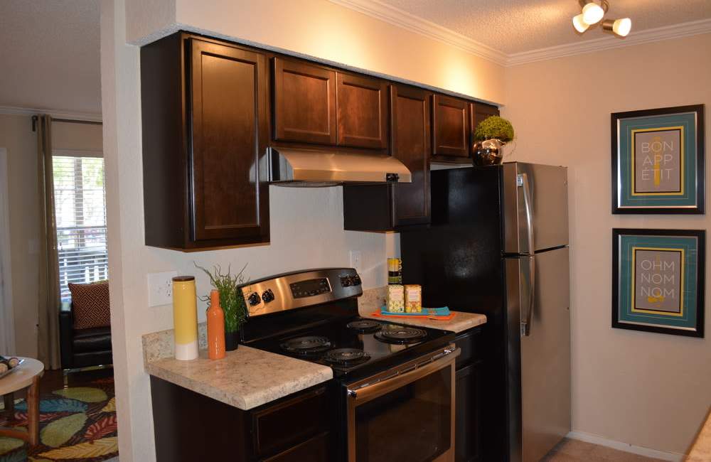 Modern kitchen with wood cabinets and granite countertop at The Abbey At Northlake in Riviera Beach, Florida