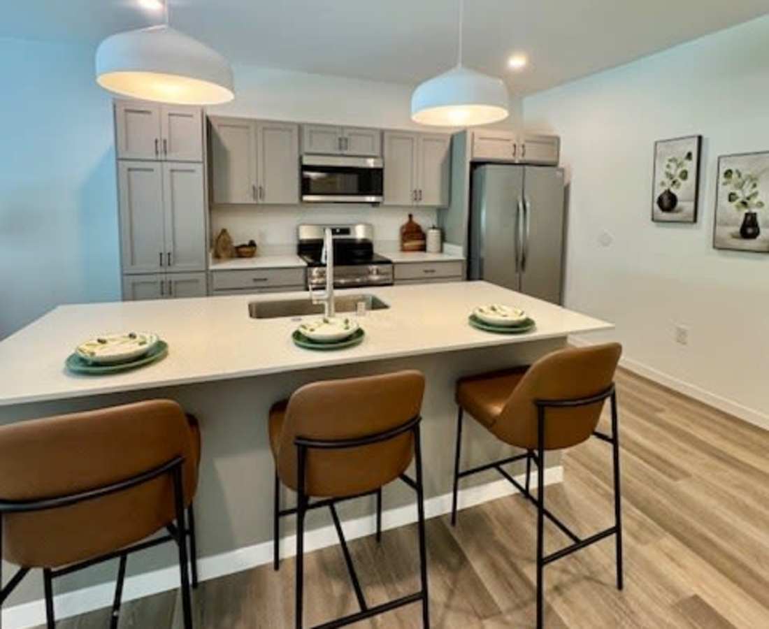 Gray cabinets and bar stools with brown seats at Pritchard Park Place in Racine, Wisconsin