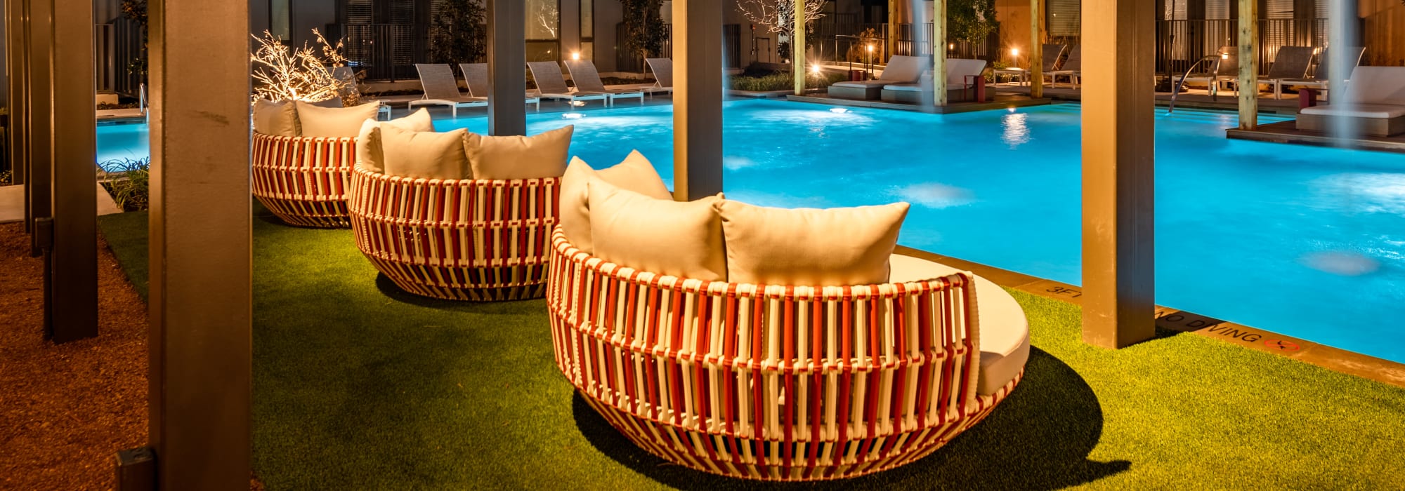 Resort-style swimming pool with shaded lounge seating nearby at The Langford in Dallas, Texas