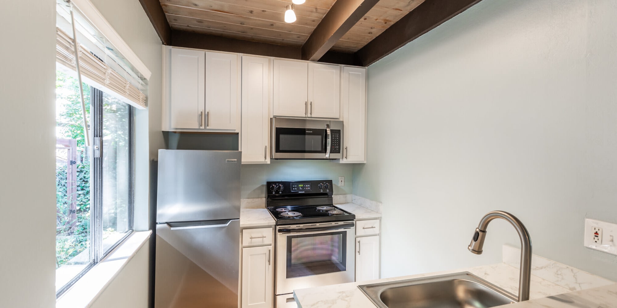 Kitchen with stainless-steel appliances and track lighting at  South Knoll in Mill Valley, California