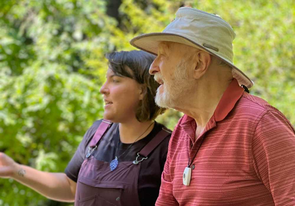 Resident having a chat with a staff member near Merrill Gardens at The University in Seattle, Washington