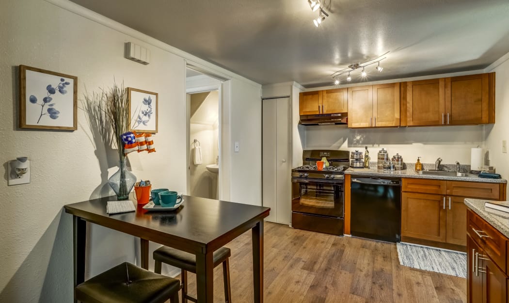 Modern kitchen with hardwood floors & custom overhead lighting in model townhome at Avalon Townhomes in Hampton, VA