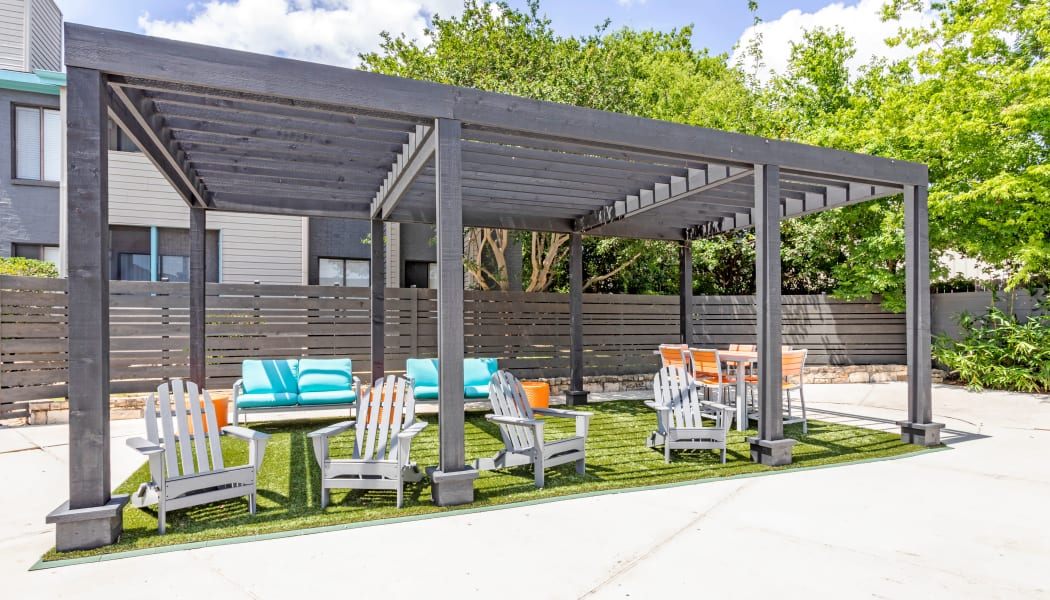 Poolside pavilion with picnic area and lounge chairs at EnVue Apartments in Bryan, Texas