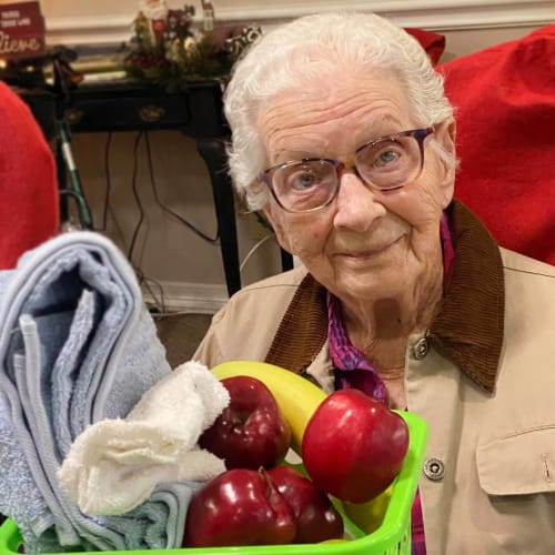 A resident sitting with a basket full of gifts at Canoe Brook Assisted Living in Ardmore, Oklahoma