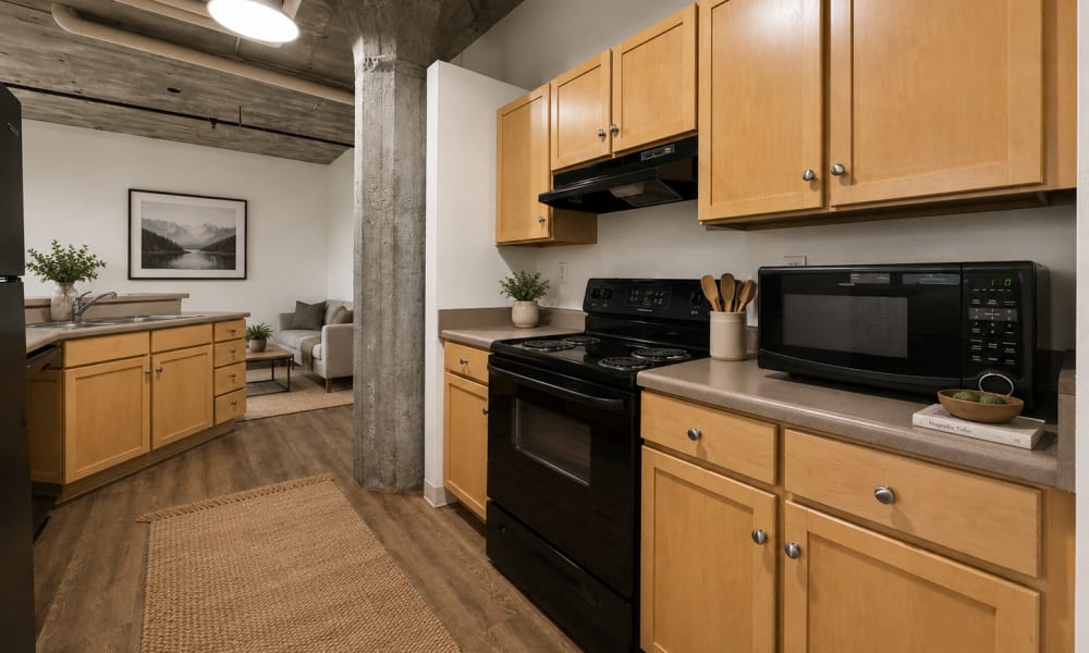 Modern kitchen with wood-style flooring and black at Crescent Lofts in Davenport, Iowa
