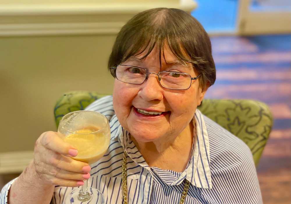 Resident posing with a beverage at Truewood by Merrill, First Hill in Seattle, Washington