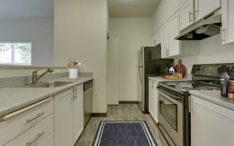 A bright and clean kitchen with white cabinets at The Landings at Morrison Apartments in Gresham, Oregon